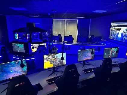 modern játékterem, több számítógéppel és monitorral, kék világítással megvilágítva